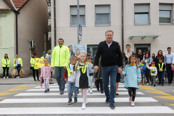 župan spremlja otroke na prehodu čez pešce